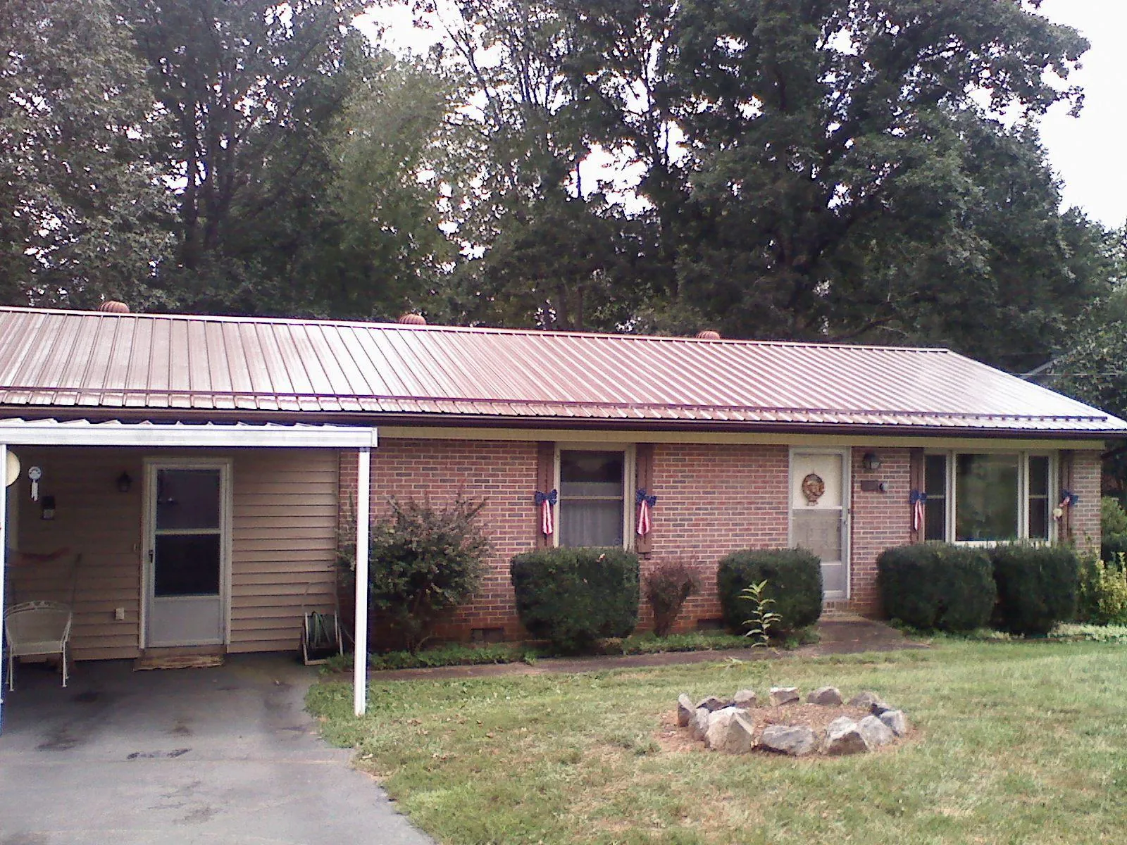 Bronze metal roof and carport on a brick ranch home — Roof Repair work by our crew in Port Gibson